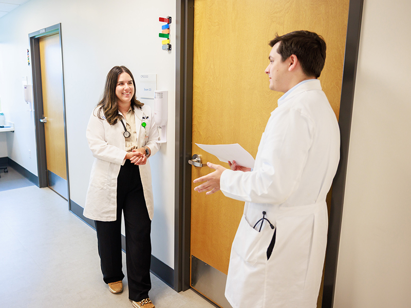 Two medicine residents conversing in UMMC Colony Park South hallway